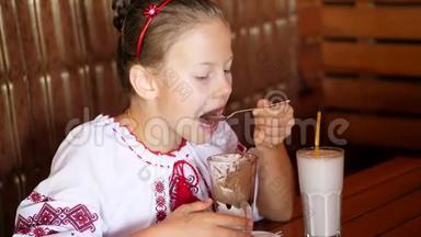 快乐的微笑<strong>少女</strong>，孩子在咖啡馆吃冰淇淋。 她穿着乌克兰民族<strong>服装</strong>，刺绣